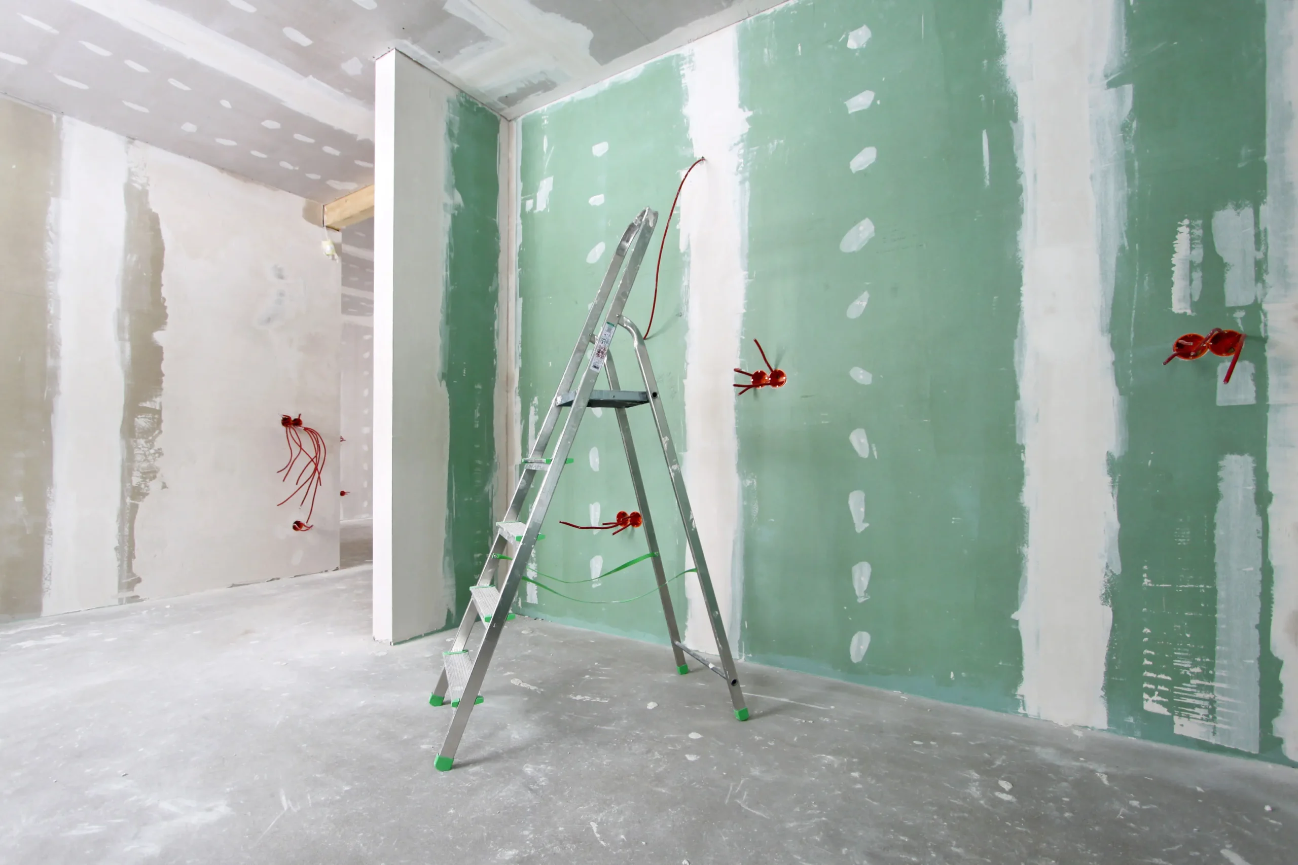 Drywall being installed on metal framing by contractor